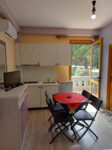 a kitchen with a table and two chairs and a table and a kitchen with at Vila Green Relax in Vlorë