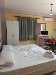 a large white bed with two towels on it at Vila Green Relax in Vlorë