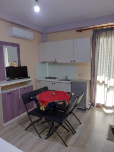 a kitchen with a table and chairs in a room at Vila Green Relax in Vlorë