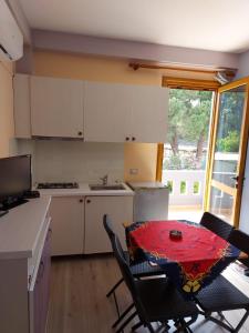 a kitchen with a table and chairs and a kitchen with a window at Vila Green Relax in Vlorë