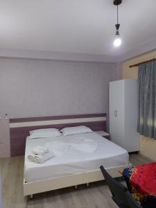 a bedroom with a bed with towels on it at Vila Green Relax in Vlorë