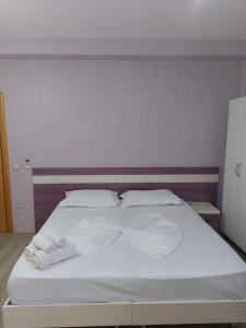 a white bed with two white towels on it at Vila Green Relax in Vlorë
