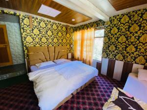 a bedroom with a large bed with yellow wallpaper at The GRITTI CASTLE HOTEL AND RESTAURANT in Kanzalwan