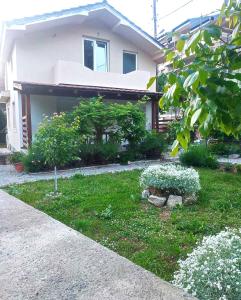 una casa con un jardín con flores delante en Apartment Serenity, en Ohrid