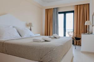 - une chambre avec un lit et des serviettes dans l'établissement Sellada Beach, à Perissa