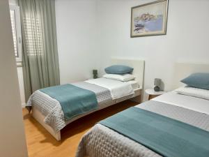 a bedroom with two beds and a window at Apartments Cvitanović Korčula in Korčula
