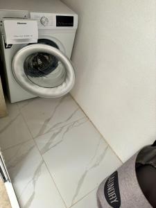 a washing machine in a room with a persons foot next to it at Apartments Cvitanović Korčula in Korčula