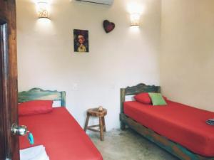 2 camas en una habitación con sábanas rojas en Tubo Tulum Hostel, en Tulum