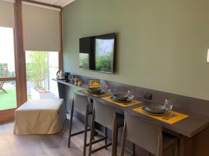 a dining room with a table with chairs and a television at Casa vacanze Clorofilla in Bergamo +28 photos