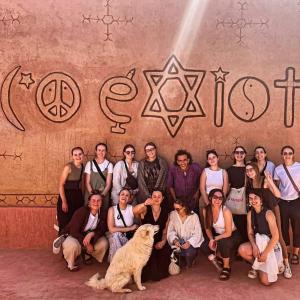 un grupo de personas posando para una foto con un perro en Ecolodge Aroma Dades en El Hart