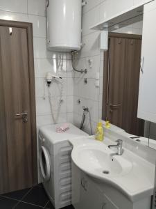 y baño con lavabo y lavadora. en Apartment Tina en Trogir