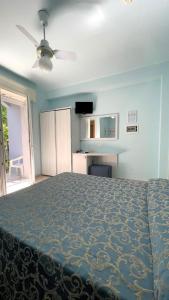 Hotel Mirabella في كاتوليكا: غرفة نوم بسرير ومروحة سقف