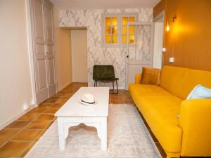 a living room with a yellow couch and a table at La chambre du soleil in Lézat-sur-Lèze