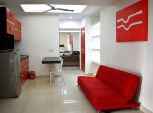 sala de estar con sofá rojo y cocina en Hotel Maya Turquesa en Playa del Carmen