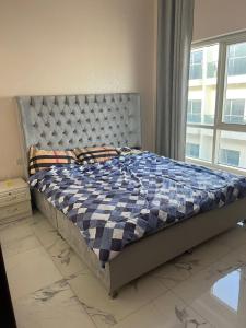 um quarto com uma cama com um edredom azul e branco em 国际城华人民宿 单间双人床 合住公寓 no Dubai