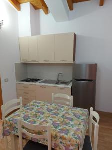 a small kitchen with a table and a refrigerator at Vila Green Relax in Vlorë