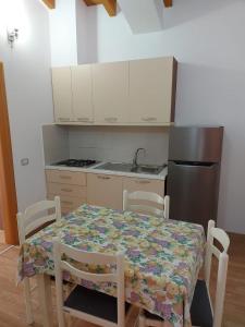 a kitchen with a table and chairs and a kitchen with a refrigerator at Vila Green Relax in Vlorë