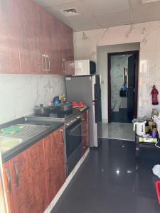 uma cozinha com um fogão, um lavatório e um frigorífico em 国际城华人民宿 单间双人床 合住公寓 no Dubai