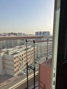 国际城华人民宿 单间双人床 合住公寓 في دبي: بلكونه مطله على مواقف السيارات