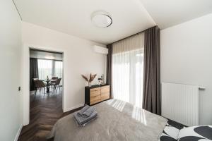 a bedroom with a bed and a dining room at Riverra House - Panorama View Apartment in Kaunas