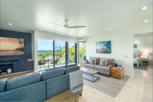 a living room with a couch and a tv at Wailea Elua Village 803, Ocean Views, Modern Reno in Wailea