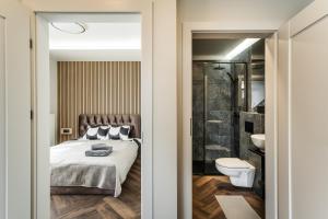 a bedroom with a bed and a bathroom with a toilet at Riverra House - Panorama View Apartment in Kaunas