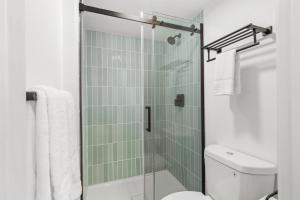 y baño con aseo y ducha acristalada. en Uptown Inn by Vantaggio Suites en San Diego