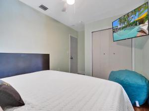a bedroom with a bed and a flat screen tv at GAYPool Side Pleasure CLOTHING OPTIONAL MENS only guesthouse in Fort Lauderdale