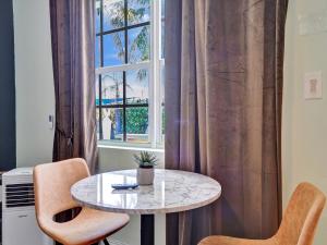 a table and two chairs in front of a window at GAYPool Side Pleasure CLOTHING OPTIONAL MENS only guesthouse in Fort Lauderdale