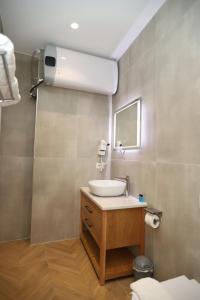 J&D Rooms Korce في كورتشي: حمام مع حوض ومرآة