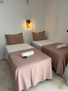 2 Betten mit Handtüchern darüber in einem Zimmer in der Unterkunft Milagres de Minas in São Miguel dos Milagres