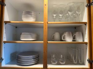 a cupboard filled with plates and glasses and dishes at Halliday House Residences Sunshine Suites and Garden Suite near Sedona and Wineries in Cottonwood