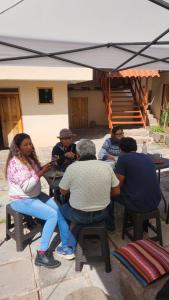 een groep mensen die aan een tafel zitten onder een paraplu bij Munay Cusco in Cuzco