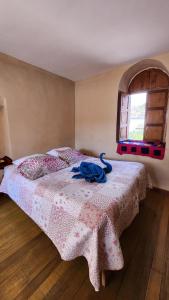 um quarto com uma cama com um cobertor rosa e uma janela em Munay Cusco em Cusco