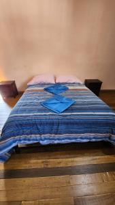 Una cama con un edredón azul encima. en Munay Cusco, en Cusco