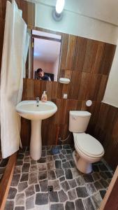 un hombre tomando una foto de un baño con aseo y lavabo en Munay Cusco, en Cusco