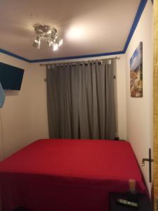 een slaapkamer met een rood bed en een plafondventilator bij Casa da Mariquinhas in Lissabon