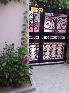 une porte noire avec un panneau et quelques fleurs dans l'établissement Апартамент-идеален център Ямбол, à Yambol