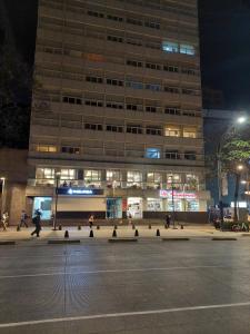 ein Gebäude in der Nacht mit Leuten, die davor laufen in der Unterkunft Punto Alameda Reforma - Carso in Mexiko-Stadt