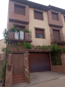 a brick building with two garage doors and windows at Casa La Parra en Teruel in Villastar