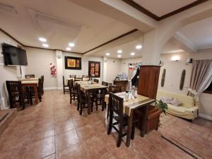 uma sala de jantar com mesas e cadeiras e uma televisão em Hostería Austral em El Calafate