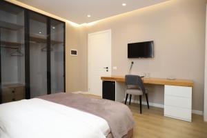 a bedroom with a bed and a desk and a tv at J&D Rooms Korce in Korçë