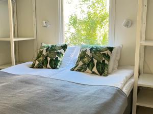 un letto con due cuscini e una finestra di STF Hotel Zinkensdamm a Stoccolma