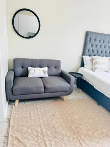1 dormitorio con sofá azul y espejo en Gallagher Midrand BnB en Midrand
