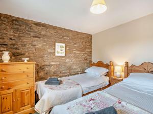 - une chambre avec 2 lits et un mur en pierre dans l'établissement 2 Bed in Kirby Stephen SZ478, à Ravenstonedale