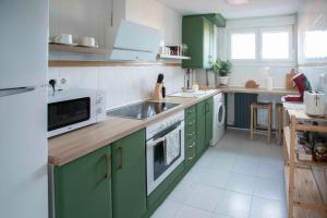 a kitchen with green cabinets and white appliances at El Mirador del Pilar - Parking y vistas a la basílica in Zaragoza