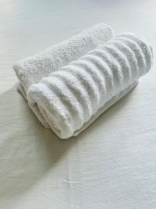 a white towel laying on top of a bed at Gallagher Midrand BnB in Midrand