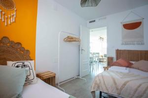 1 dormitorio con 2 camas y pared de color naranja en Acogedor apartamento con vistas a la basílica y 2 plazas de garaje, en Zaragoza