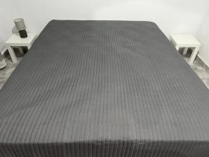 a large bed in a room with two tables at Cottage Karanikola in Sikia +2 photos