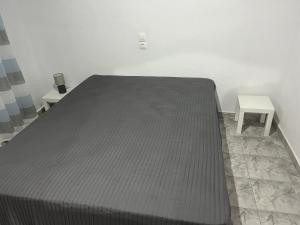 a bed in a room with two tables at Cottage Karanikola in Sikia